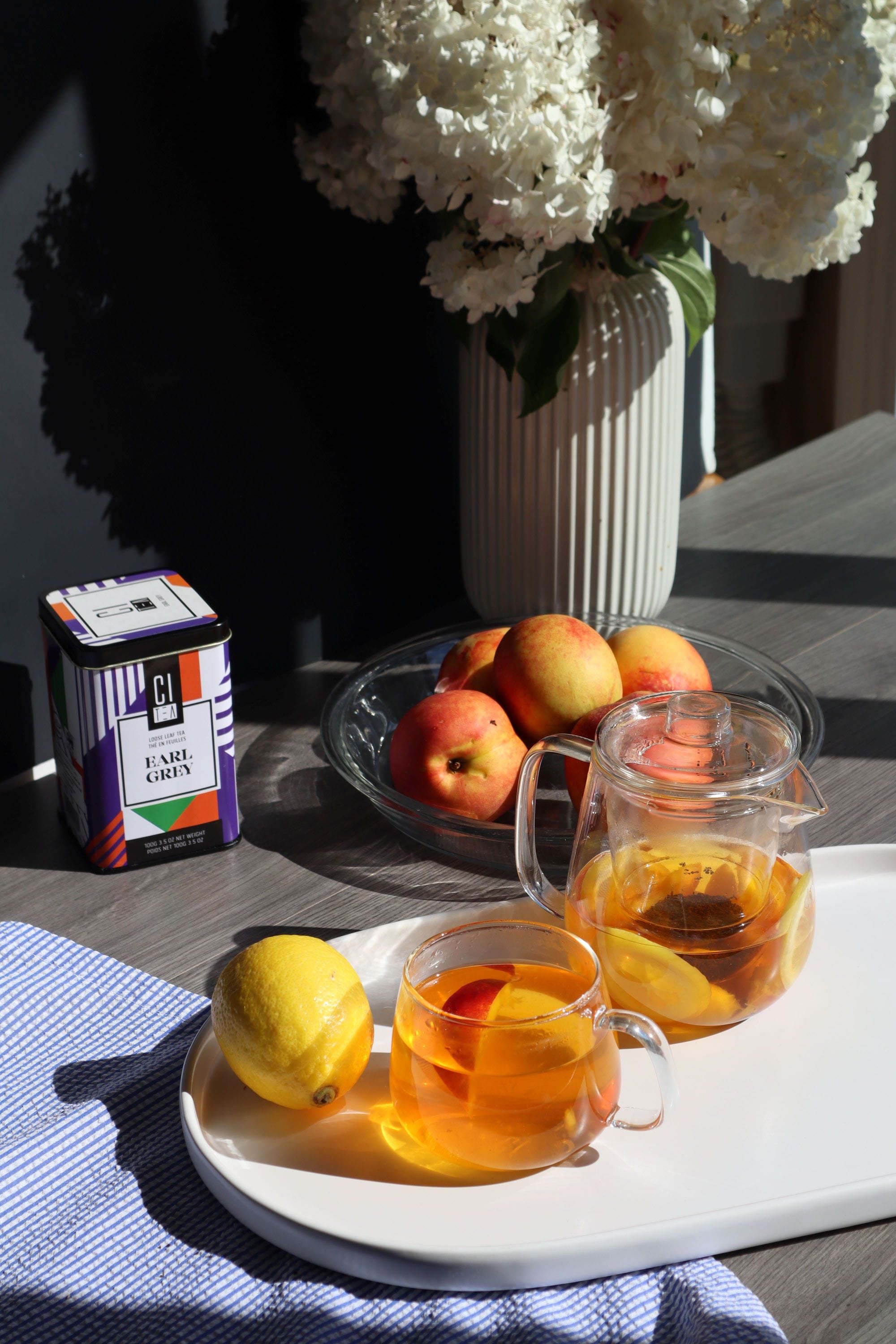 Earl grey tea on table with fruits, small teapot and teacup